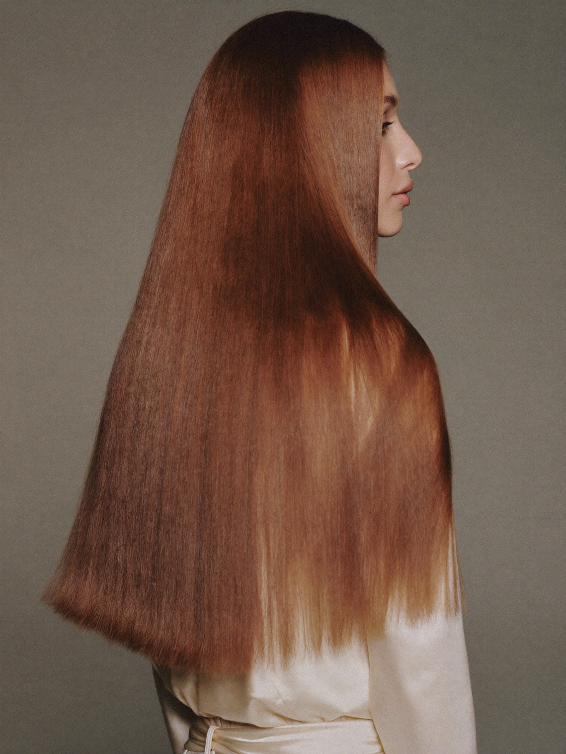Long glossy hair falling down a woman's back, seen in profile